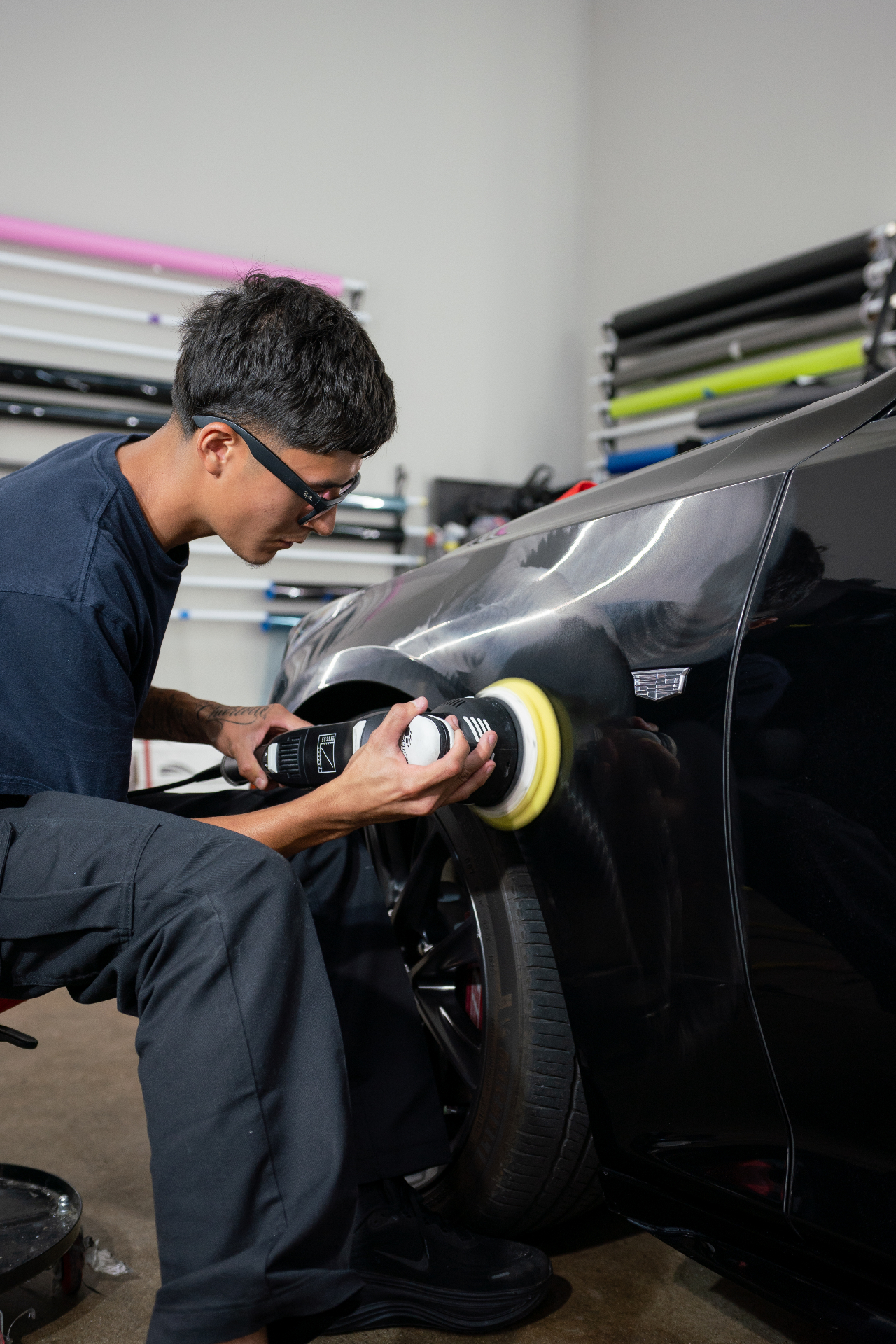 NTX Auto Care technician machine polishing a Cadillac fender during paint correction