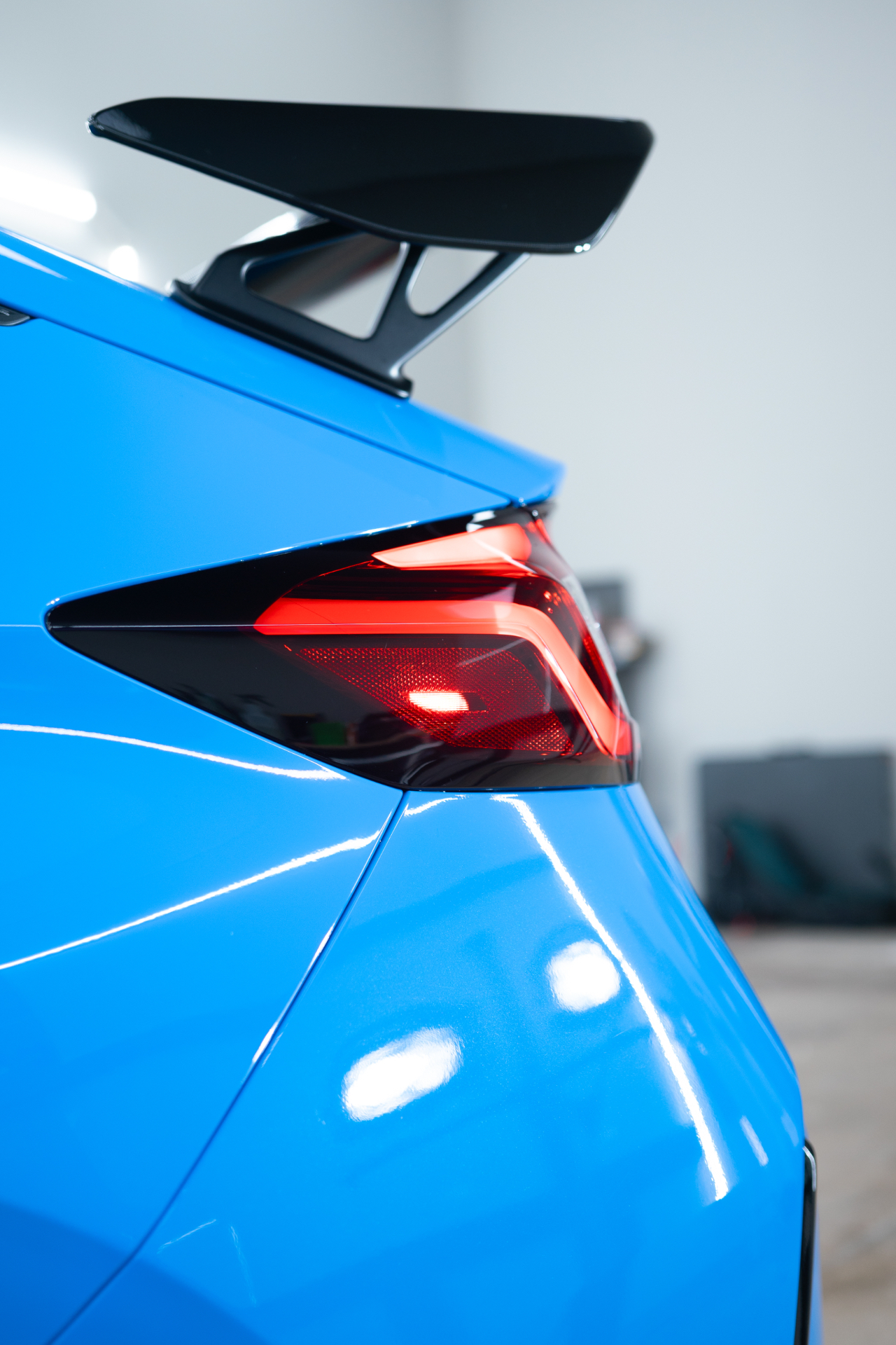 Close-up of a coated blue Honda Civic Type R taillight and rear quarter panel