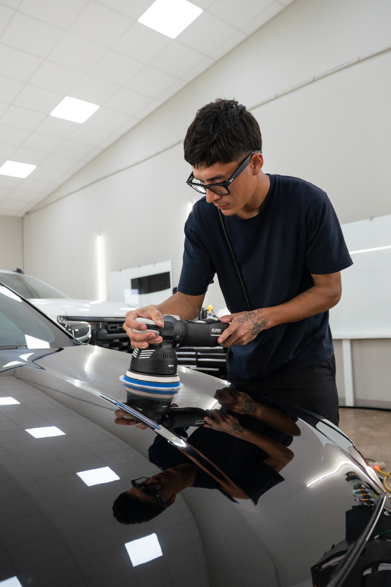 Machine polishing a Cadillac hood to a mirror finish before ceramic coating